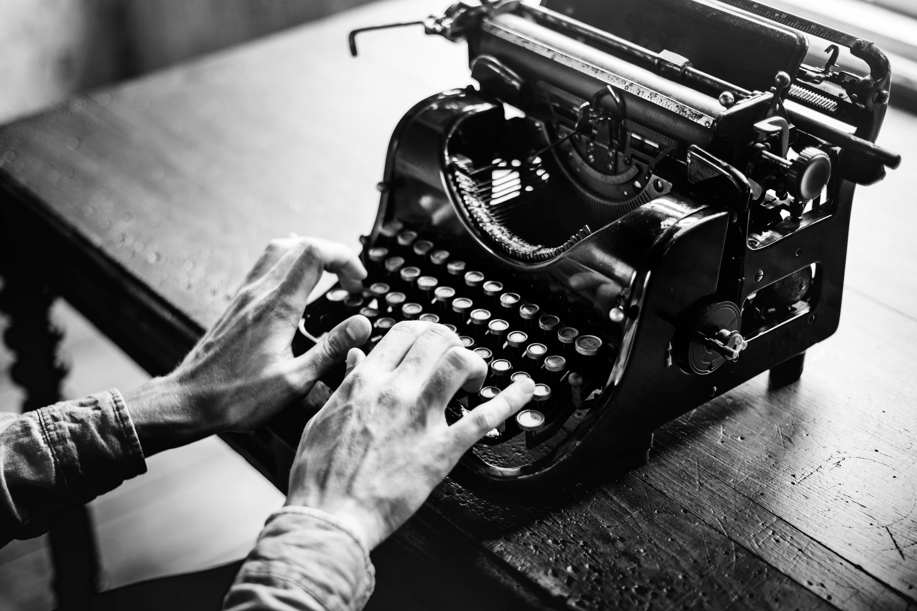 What Screenwriters & Novelists Can Learn From One Another - Image of Man Typing on Vintage Typewriter